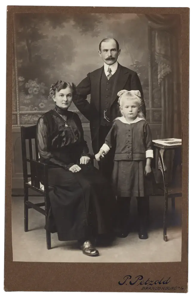 Familienporträt, Vater und Tochter stehend, Mutter sitzend